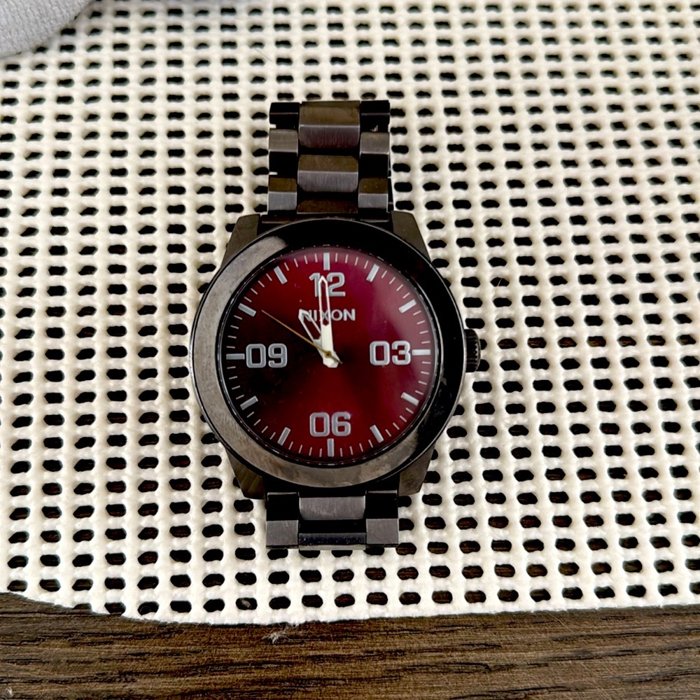 Nixon Corporal. Maroon face and gun metal band.